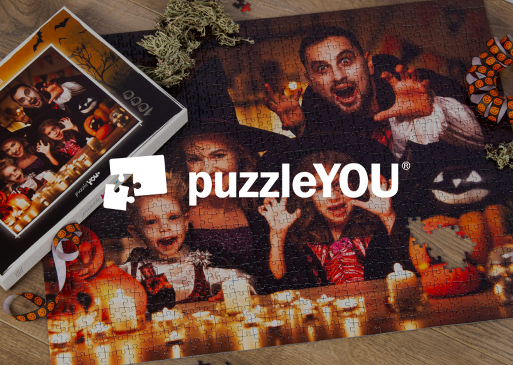 Image of a Halloween jigsaw puzzle on a table with the puzzleYOU logo on top