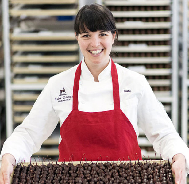 Lake Champlain Chocolates Employee in a kitchen and holding a tray of chocolates