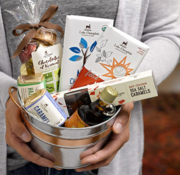 Person holding a gift basket of Lake Champlain Chocolates