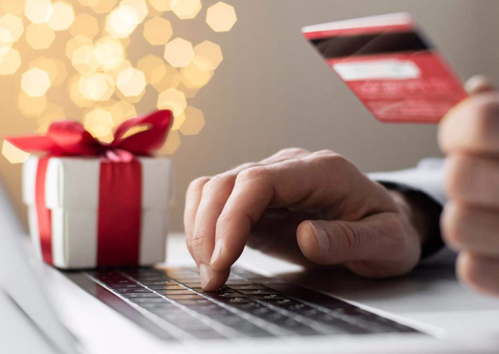 Man on Christmas shopping on a laptop.